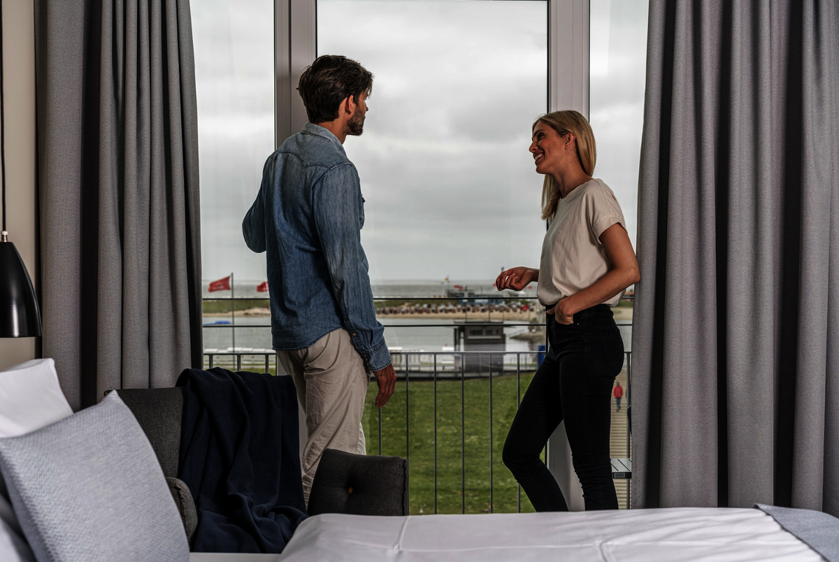 Gäste im Hotelzimmer der Küstenperle Büsum mit Blick nach draußen