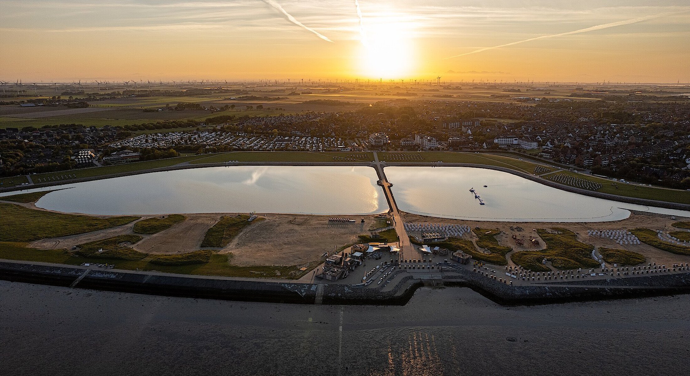 Blick vom Wasser auf das Hotel Küstenperle an der Familienlagune Perlebucht in Büsum – Nordsee Urlaub in bester Lage